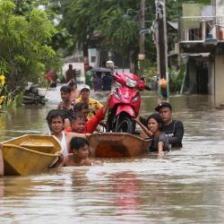 Residentes transportan una motocicleta en un bote para en medio de las inundaciones dejadas por las lluvias torrenciales del tifón Doksuri en Calumpit, provincia de Bulacan, Filipinas. | Foto:Earvin Perias / AFP