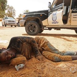 Un migrante de origen africano se desploma a su llegada a una zona deshabitada cerca de Al-Assah, en la frontera entre Libia y Túnez. | Foto:Mahmud Turkia / AFP