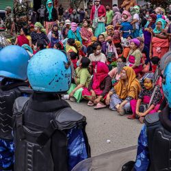Personal de seguridad monta guardia mientras los manifestantes protestan contra el entierro masivo de los kuki-zomi muertos en la violencia étnica de Manipur, en Imphal, India. | Foto:AFP