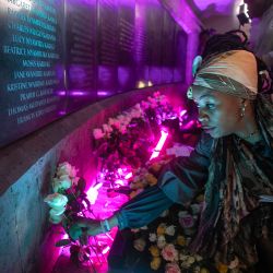 Un familiar de una víctima del atentado terrorista de 1998 contra la embajada de EE.UU. en Nairobi coloca su mano sobre la inscripción del nombre del fallecido en una placa conmemorativa con los nombres de los muertos en la explosión de la bomba que se cobró más de 200 vidas durante la conmemoración del 25º aniversario en Nairobi. | Foto:Tony Karumba / AFP