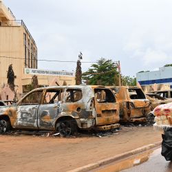 Un vendedor ambulante empuja su carro junto a coches quemados frente a la sede del Partido Nigerino para la Democracia y el Socialismo del presidente Bazoum, en Niamey. Los gobernantes militares de Níger desafiaron un ultimátum para restaurar el gobierno electo, mientras la amenaza de una posible intervención militar seguía sobre la mesa. | Foto:AFP
