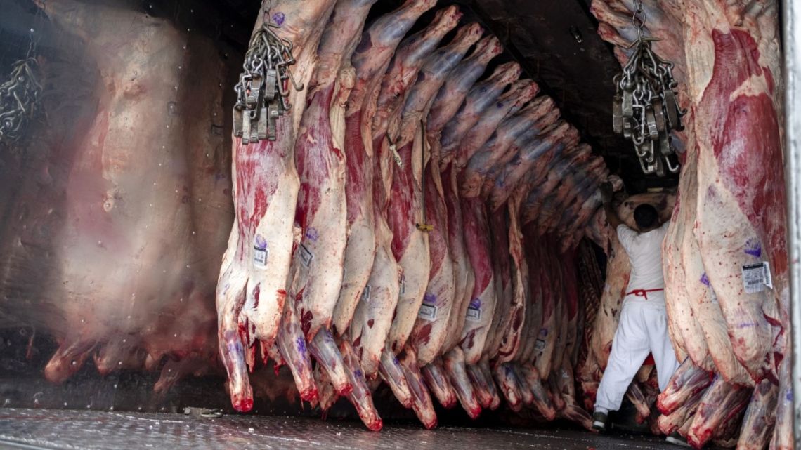 A worker moves sides of beef inside a refrigerated truck in Buenos Aires.
