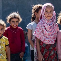 Las niñas se paran junto a una tienda de campaña en el campamento improvisado de Al-Yunani para desplazados internos en la provincia de Raqa, en el norte de Siria. Miles de personas desplazadas por 12 años de guerra están atrapadas en campamentos miserables y no oficiales en la región kurda de Siria. | Foto:DELIL SOULEIMAN / AFP