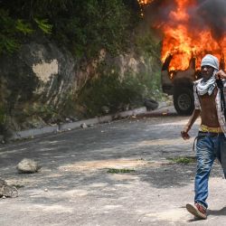 Los hombres pasan junto a un automóvil del gobierno en llamas durante una protesta contra la inseguridad, cerca de la casa oficial del Primer Ministro en Puerto Príncipe, Haití. Unas 300 mujeres y menores fueron secuestrados en Haití por bandas criminales en el primer semestre de este año, dijo Unicef, advirtiendo sobre un aumento preocupante en los secuestros que dejan "profundas cicatrices físicas y psicológicas". | Foto:Richard Pierrin / AFP