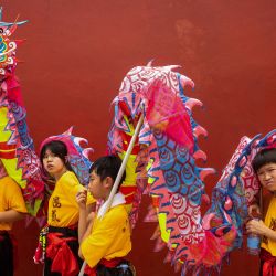 Los niños esperan para realizar una danza del dragón cerca del templo A-Ma durante las celebraciones de Kuan Tai en Macao. | Foto:Eduardo Leal / AFP