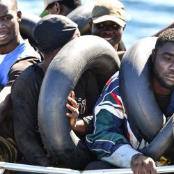 Migrantes de origen africano que intentan huir a Europa están hacinados a bordo de un bote pequeño, mientras los guardacostas tunecinos se preparan para transferirlos a su embarcación, en el mar entre Túnez e Italia. | Foto:FETHI BELAID / AFP