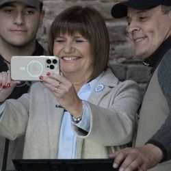 La precandidata presidencial argentina por el partido Juntos por el Cambio, Patricia Bullrich (C), se toma una selfie con los técnicos que cambiaron la máquina de votación electrónica durante las elecciones primarias en un colegio electoral de Buenos Aires, el 13 de agosto de 2023. | Foto:AFP