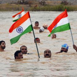 La gente sostiene las banderas nacionales de la India como parte del 'Akhand Sankalp Tiranga Yatra' en el río Narmada en la víspera de las celebraciones del Día de la Independencia del país en Jabalpur. | Foto:UMA SHANKAR MISHRA / AFP