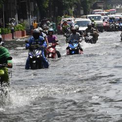 Los automovilistas atraviesan una carretera inundada después de que un fuerte aguacero provocado por el golpe de luna del sudoeste azotara Manila. | Foto:TED ALJIBE / AFP