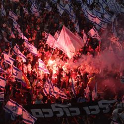 Los manifestantes usan bengalas durante una manifestación contra el plan de reforma judicial del gobierno israelí en Tel Aviv. | Foto:JACK GUEZ / AFP