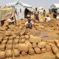 Los yemeníes reconstruyen los refugios dañados por las lluvias torrenciales con ladrillos de barro, en un campamento improvisado para desplazados internos, en el distrito de Abs, en la provincia noroccidental de Hajjah. | Foto:ESSA AHMED / AFP