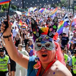 Un participante enmascarado aplaude durante el desfile del Orgullo de Praga en Praga. | Foto:Michal Cizek / AFP