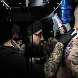 Un tatuador realiza un tatuaje a un hombre durante la Feria Expositora de Tatuajes "Cicaplast Summer Ink 2023 - Edición Invierno", en Valparaíso Chile. | Foto:Xinhua/Jorge Villegas