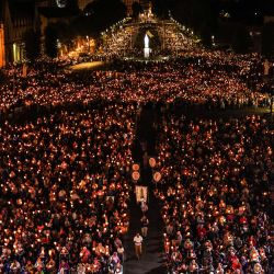 Una réplica de la estatua de la Virgen María de Cabuchet se ve entre los peregrinos que asisten a la procesión mariana de antorchas durante las celebraciones de la Asunción, en Lourdes, suroeste de Francia. | Foto:CHARLY TRIBALLEAU / AFP