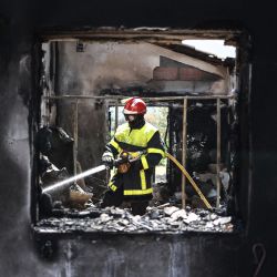 Un bombero francés apaga los restos de un incendio en una casa destruida por un incendio forestal en Saint-Andre, cerca de Argeles-sur-Mer, en el sur de Francia. | Foto:CHARLY TRIBALLEAU / AFP