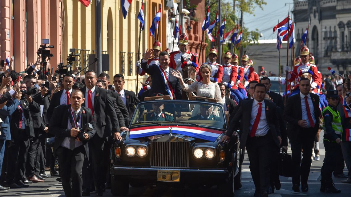Paraguay's new President Santiago Peña, with his wife First Lady Leticia Ocampos, wave at supporters after being sworn in, in Asuncion on August 15, 2023. 
