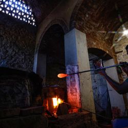El soplador de vidrio egipcio Ahmed Khaled, de 31 años, esculpe una copa en el taller de su familia cerca del complejo de la Mezquita Sultan Qaitbay del siglo XV en el área del "Desierto de los Mamelucos" (Ciudad de los Muertos) de la capital de Egipto, El Cairo. | Foto:KHALED DESOUKI / AFP