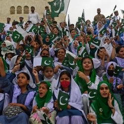 Los estudiantes ondean las banderas nacionales de Pakistán en el mausoleo del fundador del país, Mohammad Ali Jinnah, durante las celebraciones del Día de la Independencia de Pakistán en Karachi. | Foto:ASIF HASSAN / AFP