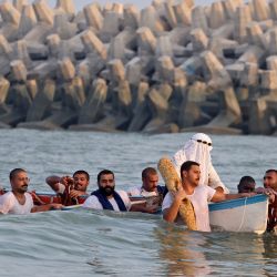 Los buzos kuwaitíes se dirigen a la playa principal durante el festival anual de buceo de perlas en la ciudad de Kuwait. | Foto:YASSER AL-ZAYYAT / AFP