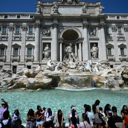 Los turistas se refrescan en la Fontana de Trevi durante una ola de calor en Roma. | Foto:FILIPPO MONTEFORTE / AFP