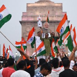 La gente ondea banderas nacionales indias mientras celebran el exitoso aterrizaje lunar de la nave espacial Chandrayaan-3 en el polo sur de la Luna, en Nueva Delhi, India. | Foto:ARUN SANKAR / AFP