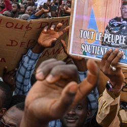Un partidario del Consejo Nacional de Seguridad de la Patria (CNSP) de Níger sostiene un cartel del nuevo gobernante militar de Níger, el general Abdourahamane Tiani, mientras se reúnen en la Place de la Concertation en Niamey. | Foto:AFP