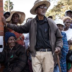 Votantes hacen cola ante un colegio electoral durante las elecciones presidenciales y legislativas de Zimbabue en Harare. | Foto:JOHN WESSELS / AFP