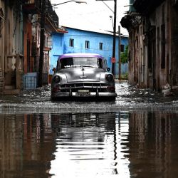 Un viejo automóvil circula por una calle inundada en La Habana, durante el paso de la tormenta tropical Idalia. La tormenta tropical Idalia se fortaleció hasta convertirse en huracán este martes y los meteorólogos pronostican que se volverá "extremadamente peligrosa" antes de tocar tierra el miércoles en Florida, Estados Unidos. | Foto:YAMIL LAGE / AFP