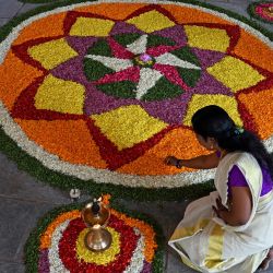 Una devota prepara Pookalam, un arreglo floral tradicional, mientras celebra el festival 'Onam' en el templo Ayyappa en Hyderabad, India. | Foto:NOAH SELAM / AFP