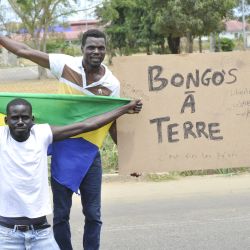 Los residentes sostienen una bandera nacional de Gabón mientras celebran en Libreville después de que un grupo de oficiales militares gaboneses aparecieran en la televisión anunciando que estaban "poniendo fin al régimen actual" y descartando los resultados electorales oficiales que habían otorgado otro mandato al veterano. Presidente Ali Bongo Ondimba. | Foto:AFP
