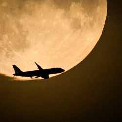 Un Airbus A320 de British Airways procedente de Belfast y preparándose para aterrizar en Heathrow, sobrevuela la luna llena que se eleva en el cielo de Londres. | Foto:JUSTIN TALLIS / AFP