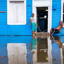 Una pareja permanece afuera de su casa en un área inundada de Batabano, provincia de Mayabeque, Cuba, mientras la tormenta tropical Idalia se acerca al extremo occidental de la nación insular. | Foto:YAMIL LAGE / AFP