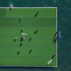 Esta vista aérea muestra a los jugadores luchando por la pelota en un campo de rugby flotante en el lago Lemán durante el Water Rugby Lausanne, un torneo de tres días organizado por LUC Rugby que reunió a más de 240 jugadores en Lausana, en el oeste de Suiza. | Foto:FABRICE COFFRINI / AFP