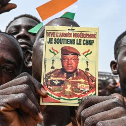 Un hombre sostiene un cartel con la imagen del nuevo gobernante militar de Níger, el general Abdourahamane Tiani, mientras los partidarios del Consejo Nacional de Salvaguardia de la Patria (CNSP) de Níger protestan frente a Níger y la base aérea francesa en Niamey para exigir la salida de el ejército francés de Níger. | Foto:AFP