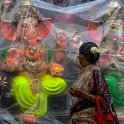 Un peatón pasa junto a ídolos envueltos en plástico de la deidad hindú Lord Ganesha a lo largo de una carretera antes del festival Ganesh Chaturthi, en Chennai, India. | Foto:Satish Babu / AFP
