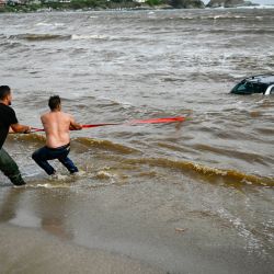 La gente intenta sacar un coche sumergido en el mar en el camping de Arapia, cerca de Tsarevo, a lo largo de la costa búlgara del Mar Negro. El número de muertos por las lluvias torrenciales y las inundaciones en la costa búlgara del Mar Negro ha aumentado a tres, dijo la policía. | Foto:NIKOLAY DOYCHINOV / AFP