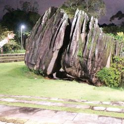 El guía del templo candomblé junto a la piedra sagrada de Xangó.