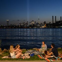 La gente observa una prueba de la exhibición de luces conmemorativa del 11 de septiembre 'Tribute in Lights', vista desde Brooklyn, en Nueva York. | Foto:ED JONES / AFP