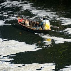Un pescador rema en un bote a través de la espuma supuestamente causada por la contaminación por desechos industriales en el río Citarum en Jelegong, Java Occidental, Indonesia. | Foto:AFP