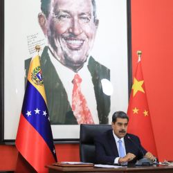 In this handout picture released by the Miraflores press office, Venezuela's President Nicolas Maduro speaks during a conference with the international press in Beijing on September 14, 2023, with a background image of Venezuela's late President Hugo Chavez. 