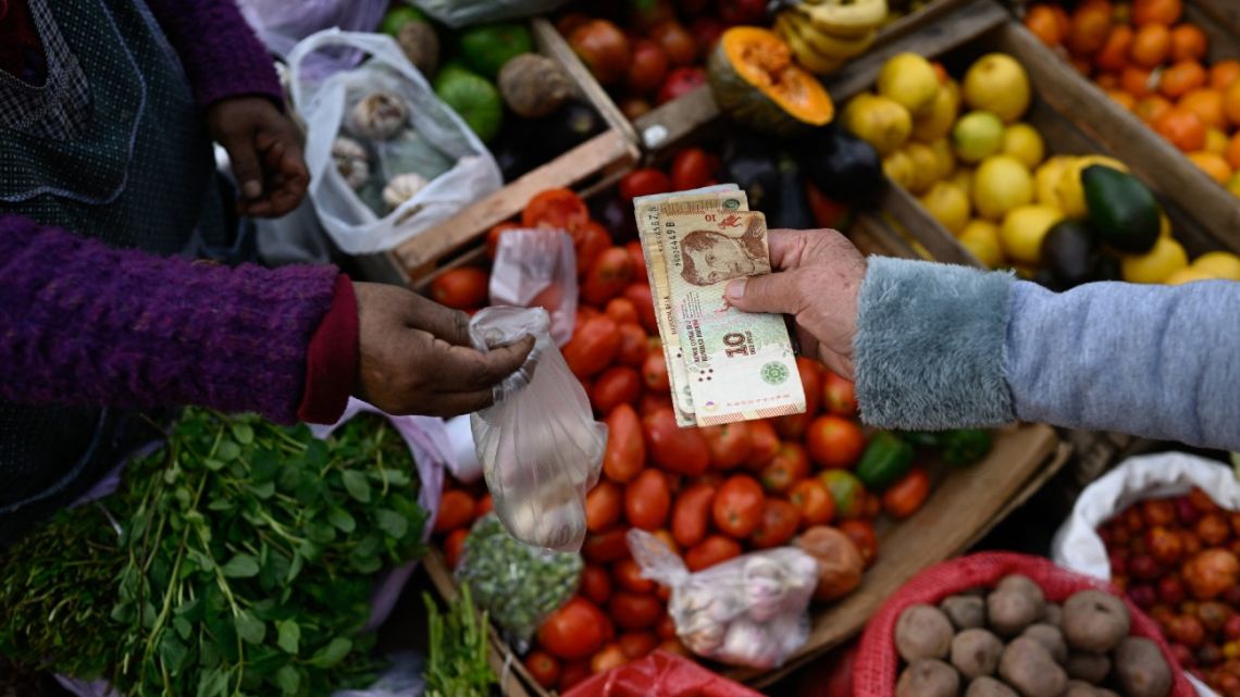 A man pays for his groceries with peso banknotes in Buenos Aires on September 11, 2023.