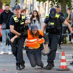 La policía se lleva a una activista climática que tiene un trozo de superficie de la carretera en la mano en Berlín. Foto de Odd ANDERSEN / AFP | Foto:AFP