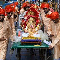 Devotos hindúes empujan un carro con un ídolo de la deidad hindú con cabeza de elefante, Lord Ganesha, durante una procesión 'Ganesh Chaturthi' en Mumbai . Foto de Punit PARANJPE / AFP | Foto:AFP