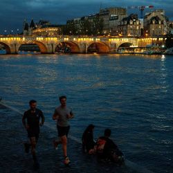 Hombres trotan a lo largo de la orilla del río Sena cerca del puente Pont Neuf en el centro de París. Foto de Dimitar DILKOFF / AFP | Foto:AFP