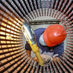 Un trabajador comprueba el núcleo de un rotor utilizado para turbinas eólicas en una fábrica en Nantong, en la provincia oriental china de Jiangsu. Foto de AFP  | Foto:AFP