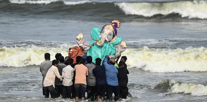 Los devotos hindúes llevan un ídolo del dios hindú Ganesh para sumergirlo en la Bahía de Bengala durante el festival 'Ganesh Chaturthi' de diez días de duración en Chennai. Foto de R. Satish BABU / AFP