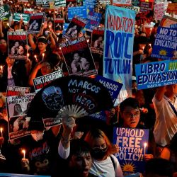 Los manifestantes levantan pancartas y encienden velas mientras se unen a una protesta que conmemora el 51.º aniversario de la imposición de la ley marcial, en Mendiola, Manila. Foto de JAM STA ROSA / AFP | Foto:AFP