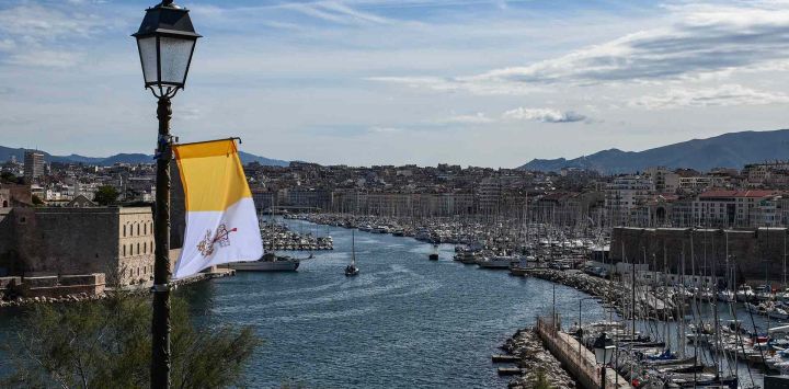 Vista del Puerto Viejo de Marsella y del Fuerte Saint-Jean, con una bandera del Vaticano sostenida en un farol, antes de la visita del Papa a la ciudad. Foto de CHRISTOPHE SIMON / AFP