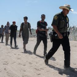 Migrantes de Venezuela caminan detrás de un agente de la Patrulla Fronteriza de EE. UU. hacia un área de procesamiento después de cruzar el Río Grande en Eagle Pass, Texas. Docenas de migrantes llegaron a la frontera entre Estados Unidos y México con la esperanza de que se les permitiera ingresar. Estados Unidos, donde las fuerzas fronterizas estadounidenses informaron de 1,8 millones de encuentros con migrantes en los últimos 12 meses. | Foto:ANDREW CABALLERO-REYNOLDS / AFP