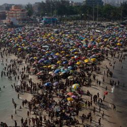 Turistas disfrutan de la playa de Macumba, en la zona oeste de Río de Janeiro, durante una ola de calor que registró 39,9 grados. | Foto:TERCIO TEIXEIRA / AFP